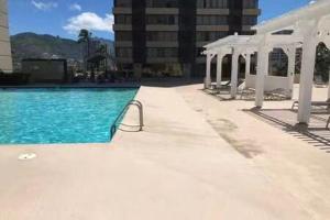 a swimming pool with blue water and a white canopy at Diamond, Ocean, and Canal view Affordable Family House in Honolulu
