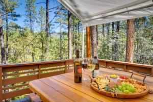 una mesa con un tazón de comida y dos botellas de vino en Pristine Pine Retreat with Deck and Outdoor Dining!, en Pine