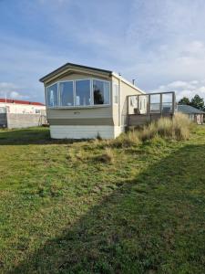 a mobile home sitting in a grass field at Chalet 304 Insel Ameland in Ballum