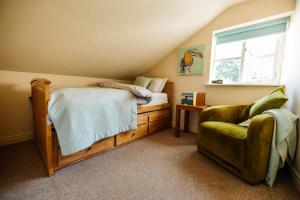 een slaapkamer met een bed, een stoel en een raam bij Langs Hall in Leyland