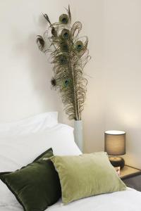 a bedroom with a bed with a vase with a plant at Maison Le Moulin Vert by La Boîte En Plus in Senlis