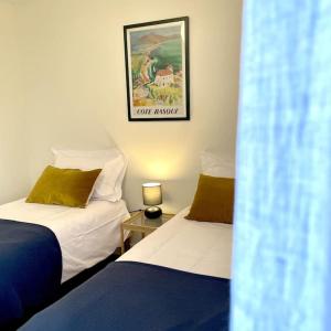 a bedroom with two beds and a picture on the wall at Maison Le Moulin Vert by La Boîte En Plus in Senlis