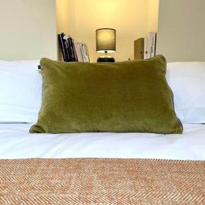 a green pillow sitting on top of a bed at Maison Le Moulin Vert by La Boîte En Plus in Senlis +13 photos