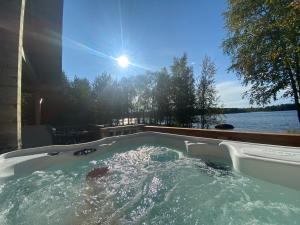a jacuzzi tub with the sun in the background at Nellim Holiday Home in Nellimö