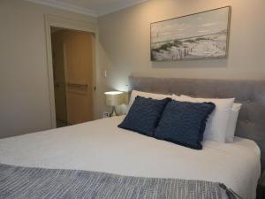 a bedroom with a large bed with blue pillows at On The Terrace Stanley in Stanley