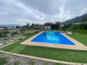 a man is standing in front of a swimming pool at Cabaña en Olmue con piscina compartida in Granizo