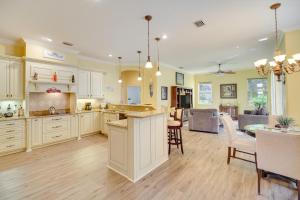 a large kitchen with white cabinets and a dining room at Ranch-Style Florida Retreat with Pool and Lanai in Merritt Island