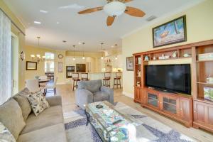 uma sala de estar com um sofá e uma televisão de ecrã plano em Ranch-Style Florida Retreat with Pool and Lanai em Merritt Island