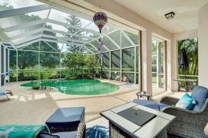a patio with a swimming pool and a large window at Ranch-Style Florida Retreat with Pool and Lanai in Merritt Island