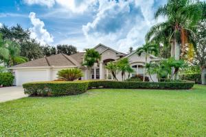 a house with palm trees in front of a yard at Ranch-Style Florida Retreat with Pool and Lanai in Merritt Island