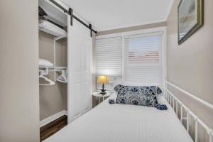 um pequeno quarto com uma cama e uma janela em Seaside Cottage: A 'MyShoreCottage' Property em Seaside Heights
