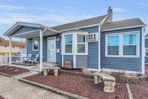 una casa blu con una panchina davanti di Seaside Cottage: A 'MyShoreCottage' Property a Seaside Heights