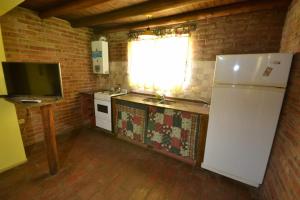 a kitchen with a white refrigerator and a window at Viejo Molino in Nono