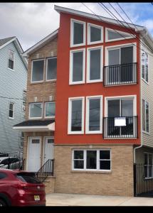 un edificio rosso con finestre bianche su una strada di Cozy & Deluxe Apartment - EZ Access to NYC a Newark