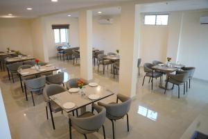 a restaurant with tables and chairs in a room at Zip By Spree Hotels Bhopal in Bhopal