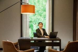 a man sitting at a desk with a laptop at Hotel GrandBach Tokyo Ginza in Tokyo