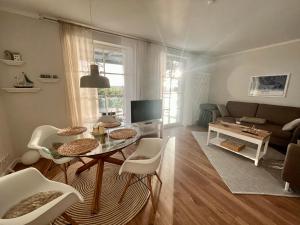 a living room with a table and a couch at Traumwohnung mit Stadthafen-Panorama! Zwei Schlafzimmer, Parkplatz in Rostock