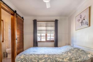 a bedroom with a bed and a window at Swan Lake Escape in Sussex inlet