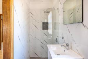 a white bathroom with a sink and a mirror at Swan Lake Escape in Sussex inlet +7 photos