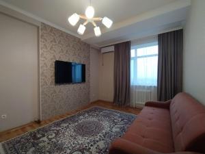 比什凱克的住宿－AURA on Isanov street 118，带沙发和平面电视的客厅
