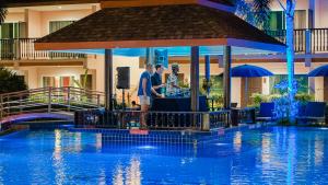 a group of people standing next to a swimming pool at Chivatara Resort Bang Tao Beach Phuket - SHA in Bang Tao Beach