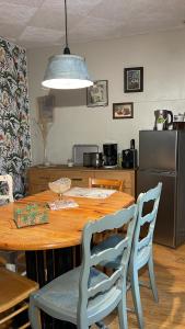 cocina con mesa de madera con sillas y comedor en appartement Vintage a l ancienne forge, en Muhlbach-sur-Munster