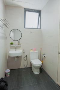 a bathroom with a toilet and a sink and a mirror at AAIRA Troika Residence,Kota Bharu in Kota Bharu