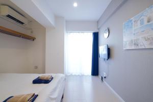 Camera bianca con letto e finestra di Good Life Apartment - Vacation STAY 08485v a Naha