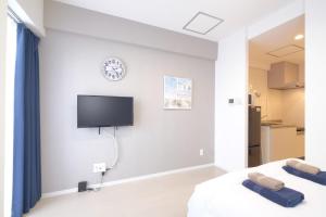 una camera con due letti e una TV a parete di Good Life Apartment - Vacation STAY 08485v a Naha