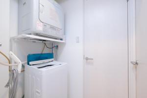 una camera con lavatrice e asciugatrice accanto a una porta di Good Life Apartment - Vacation STAY 08485v a Naha