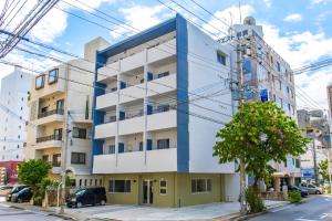 un edificio blu e bianco su una strada cittadina di Good Life Apartment - Vacation STAY 08485v a Naha