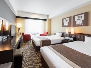 a hotel room with two beds and a television at Hotel New Hankyu Kyoto in Kyoto