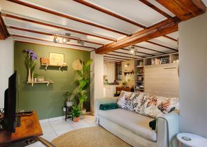 uma sala de estar com um sofá e uma televisão em Elsewhere Treehouse and Apartment on the River em Muldersdrift