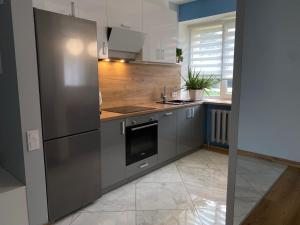 a kitchen with stainless steel appliances and wooden floors at Rezekne Lux Apartments in Rēzekne
