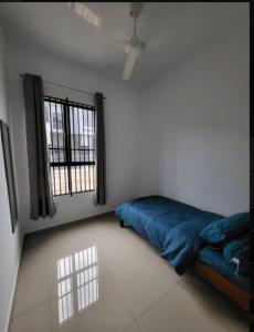 18Homestay @ Temerloh في تيميرلوه: غرفة نوم بسرير ازرق ونافذة