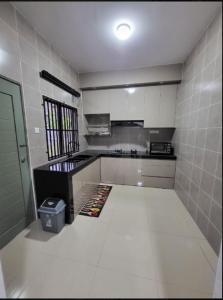 a kitchen with white tile walls and a white floor at 18Homestay @ Temerloh in Temerloh