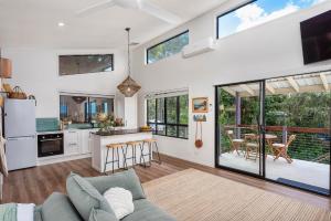 uma sala de estar com um sofá e uma cozinha com janelas em Sheket em Gold Coast