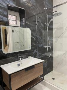a bathroom with a sink and a shower and a mirror at SULTAN PLAZA Borovoe in Borovoye