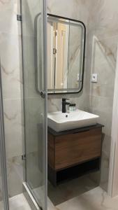 La salle de bains est pourvue d'un lavabo et d'un miroir. dans l'établissement SULTAN PLAZA Borovoe, à Borovoe