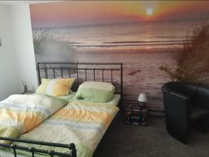 1 dormitorio con 1 cama y una pintura de playa en Ferienhaus auf Rügen, en Gingst