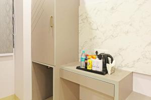 baño con encimera con fregadero y armario en Frankstay By Hotel Mayfair Residency en Nueva Delhi