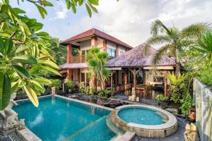 a villa with a swimming pool in front of a house at Villa Kenanga in Meninting By The Beach in Mataram