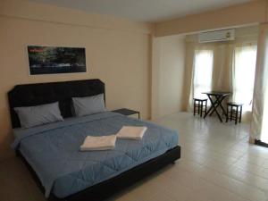 a bedroom with a bed with two towels on it at ซิตี้ แม่นชั่น in Ban Ai Dao