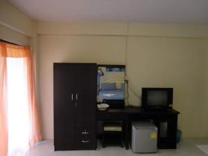 a room with a desk with a television and a room with a window at ซิตี้ แม่นชั่น in Ban Ai Dao