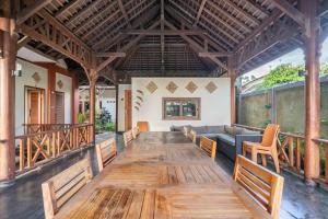- un salon avec une grande table en bois et un canapé dans l'établissement Villa Kenanga in Meninting By The Beach, à Mataram