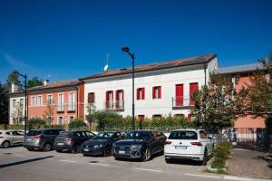 un estacionamiento con autos estacionados frente a un edificio en Appartamento Cansiglio, en Cappella Maggiore