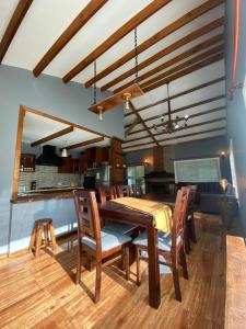 Un comedor con mesa y sillas de madera. en Lodge Dream Pucon, en Pucón