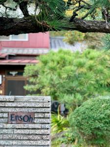 un segno per un'istituzione di fronte ad alcuni alberi di Ensoh a Okayama