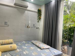 a bed in a room with a window and a curtain at Home Sweet Home in Tây Ninh