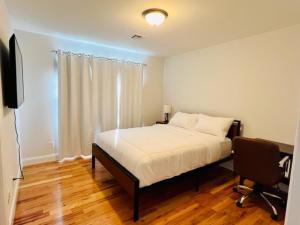 una camera con letto, scrivania e TV di Cozy & Deluxe Apartment - EZ Access to NYC a Newark
